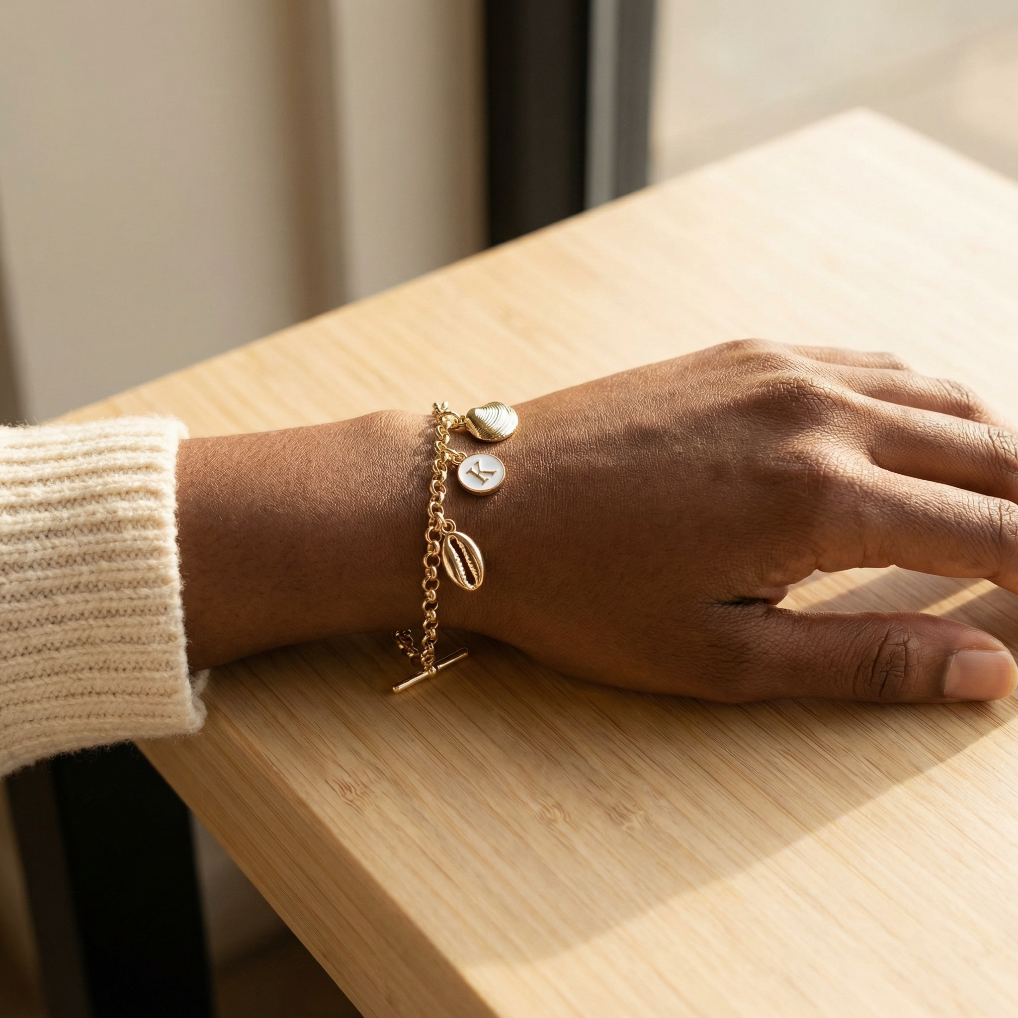 Seashell Charm Bracelet on Model - Wrist on Table Close-up