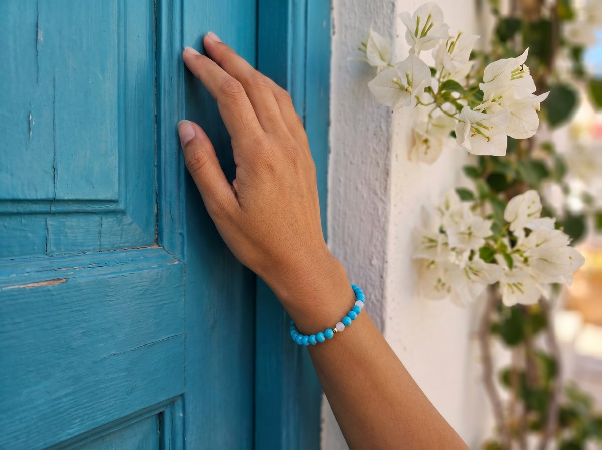 Turquoise and White Jade Bracelet on wrist against blue Mediterranean door with bougainvillea