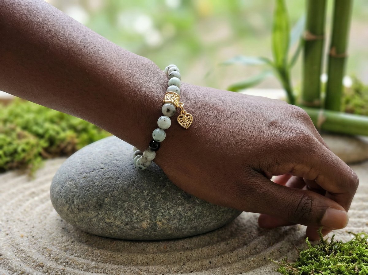 Sesame Jasper Heart Charm Bracelet on wrist with zen garden stones and bamboo