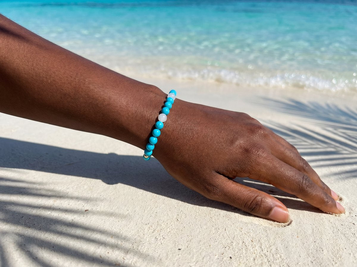 Turquoise and White Jade Bracelet on wrist on tropical beach with palm shadow